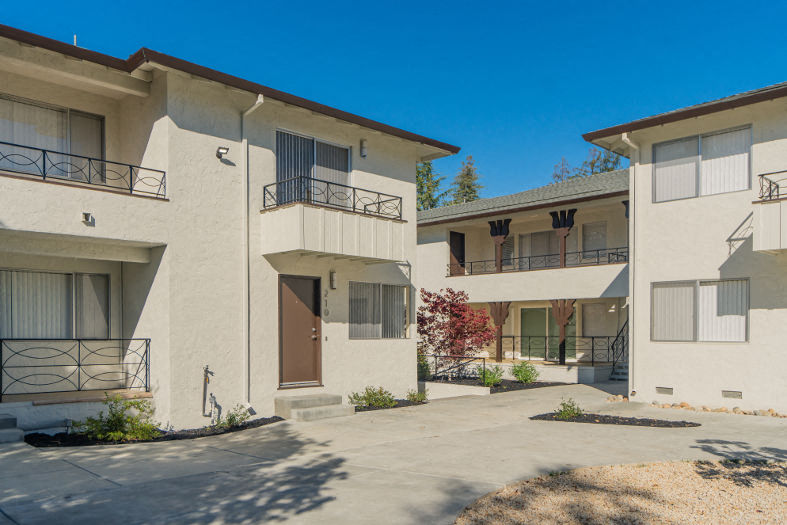 a group of apartments with balconies and a sidewalk